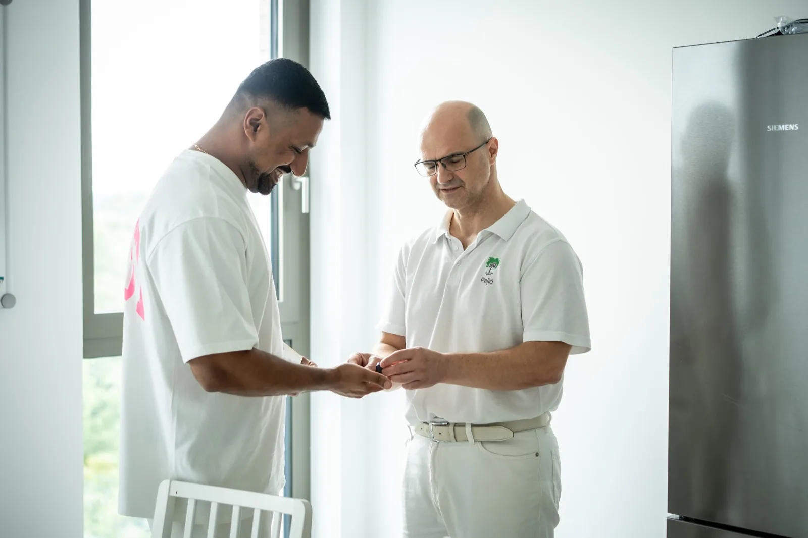 Arzt untersucht die Hand eines Patienten im Behandlungsraum